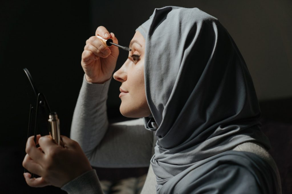 hijab woman applying eye lash halal cosmetics