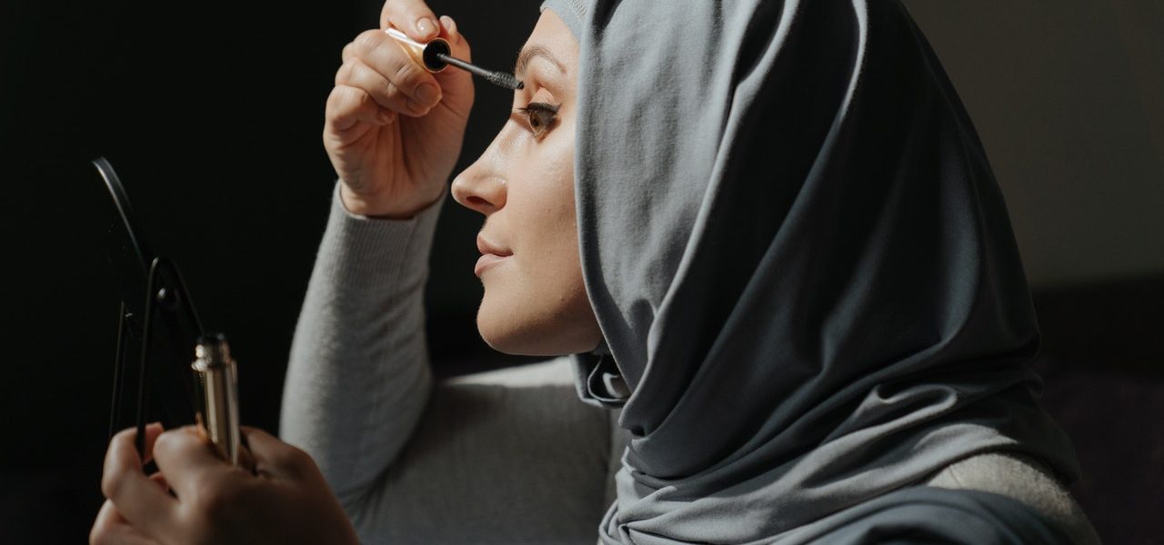 hijab woman applying eye lash halal cosmetics